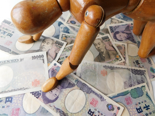 お金の上でうなだれる。茅野市で借金返済の無料相談をする